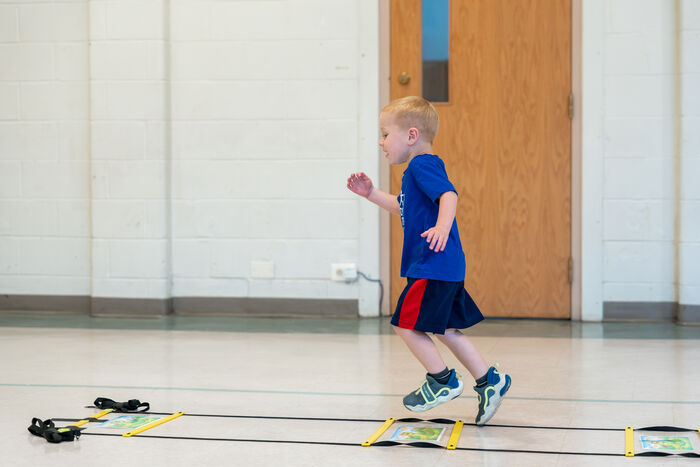 Preschooler running an agility ladder drill