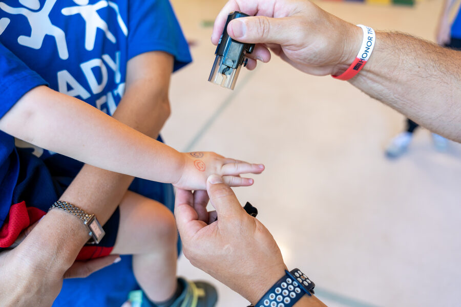 A child receiving a hand stamp at the end of a Ready Set Fit class